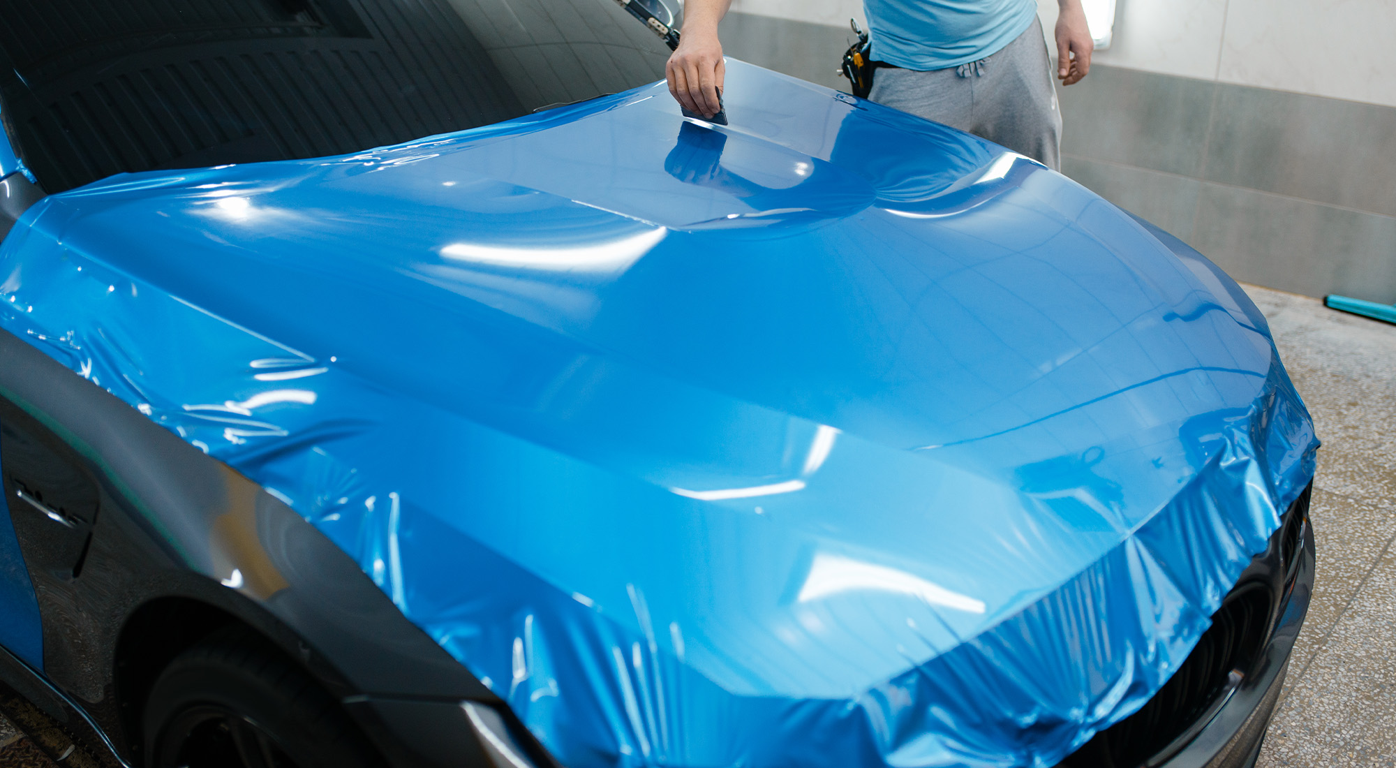 Bright blue vinyl wrap on a sports car hood