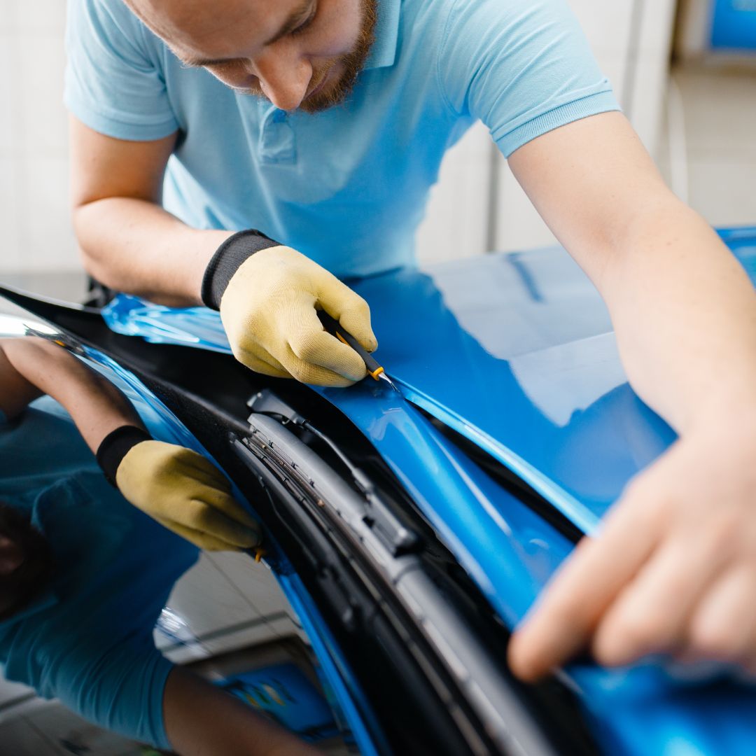 Installer trimming a hood line